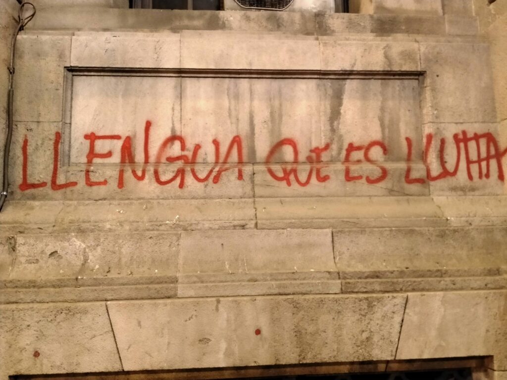 Pared callejeras con graffitis de color rojo que pone en catalán: una lengua que es lucha. Es importante elegir bien el idioma de tu proyecto en Barcelona